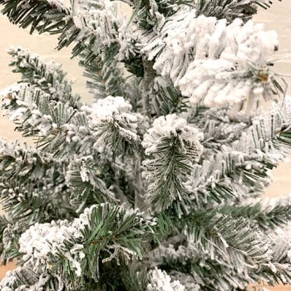 Mini juletræ med sne og potte. Detaljebillede af gren.